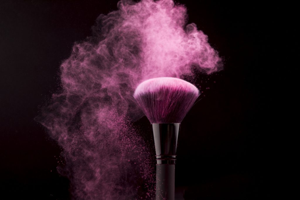cosmetic brush cloud pink powder dark background